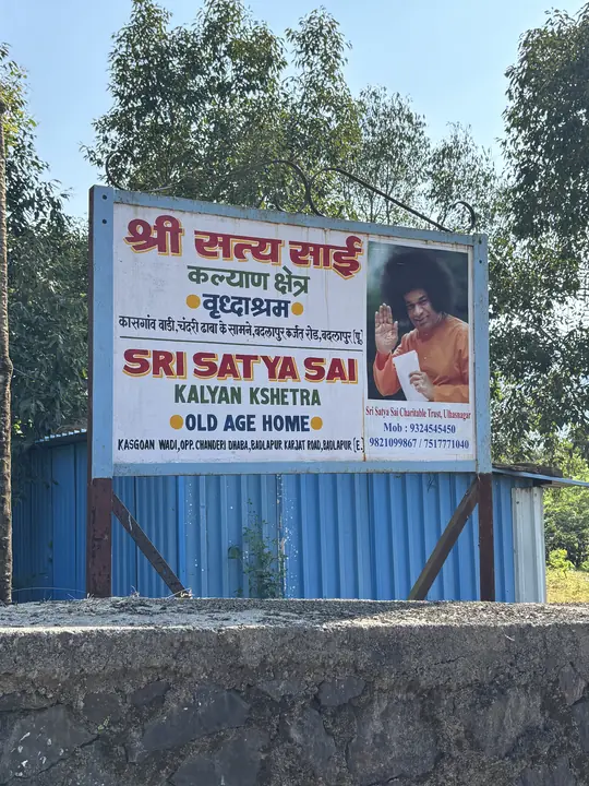 The signboard at the entrance of Shree Satya Sai Kalyan Kshetra, an old age home, with trees behind it